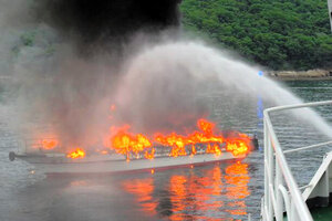 瀬戸内海の香川県・男木島沖で炎を上げる「第二十七むくじ丸」。手前は消火活動中の巡視艇=高松海上保安部提供